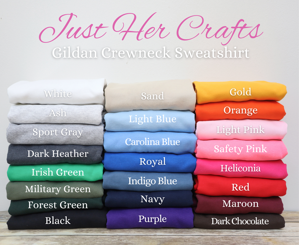 A color options display for a Gildan crewneck sweatshirt under the brand name Just Her Crafts. The image shows six columns of folded sweatshirts in various colors, labeled with names like White, Sand, Gold, Orange, Light Blue, Royal, Light Pink, Safety Pink, Irish Green, Military Green, Forest Green, Black, Navy, Purple, Red, Maroon, and Dark Chocolate on a light background.